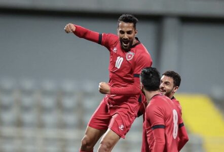 المنتخب الأردني "النشامى" يحتفلون بعد مباراة كرة قدم، مع شعار فيفا في الخلفية.